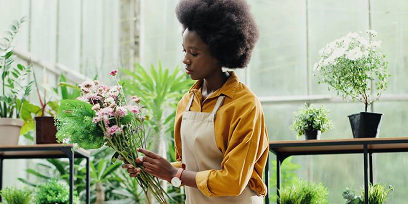 Gwerthwraig flodau yn trefnu blodau