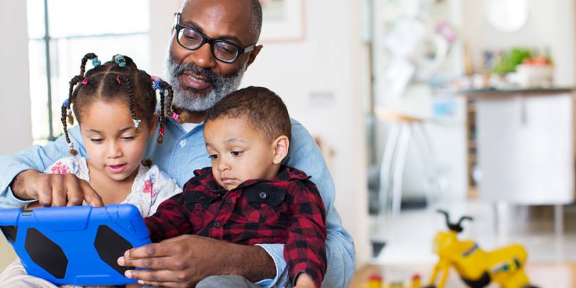 Dyn yn dal dau blentyn ifanc