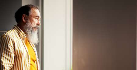 Older man looking out of window Older man looking out of window