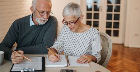 Senior couple looking at their budget together at home Senior couple looking at their budget together at home