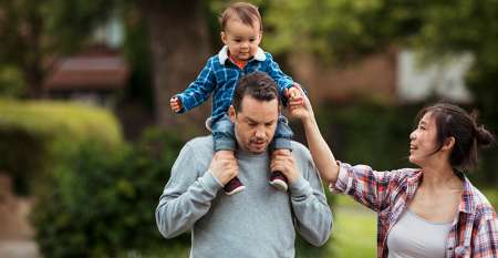 Woman with man carrying baby on his shoulders Woman with man carrying baby on his shoulders