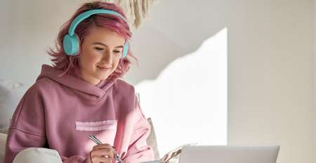 Young girl using headphones on laptop Young girl using headphones on laptop