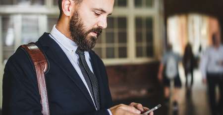 Young man in suit checking his mobile