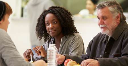 Young woman and older man sitting smiling Young woman and older man sitting smiling