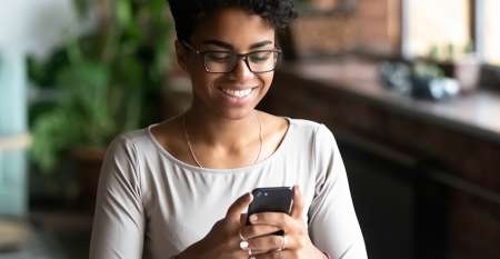 Young woman smiling while texting