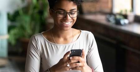 Young woman smiling while texting