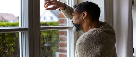 Man looking out window