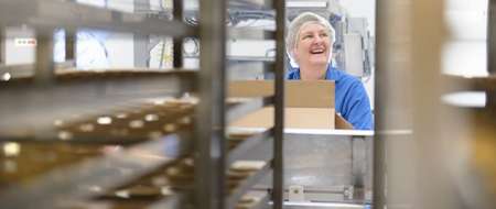 Older woman working in factory smiling