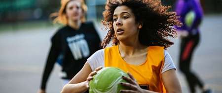 Young woman running with ball