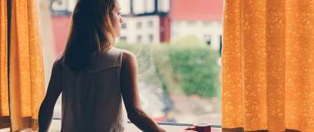 Young woman staring out window