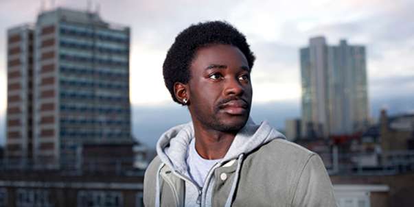 Young man in city with tower blocks